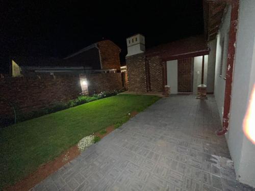 a walkway leading to a building at night at Townhouse on 6526 Boiketlo Street, Golfview in Mahikeng
