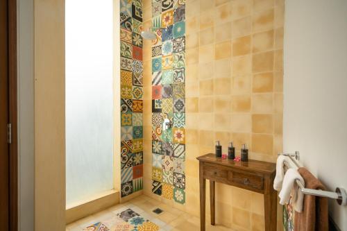 a bathroom with a shower with a wooden table at Prabhu Ubud Villa in Ubud