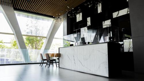 a kitchen with black walls and a marble counter and chairs at One Living At Menara One in Solo