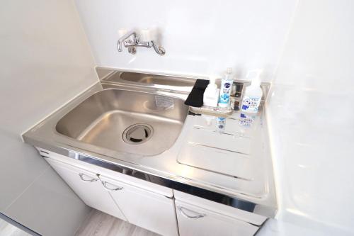 a sink in a small kitchen with a sink at パークサイドモリ in Motobu