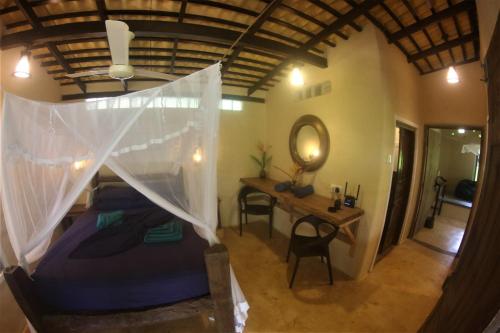 a bedroom with a bed with a mosquito net at The Spice House Mirissa in Mirissa