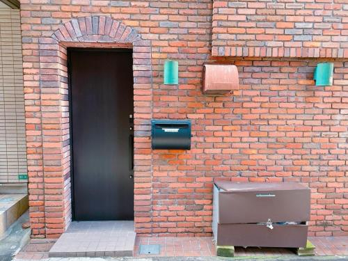 un mur en briques avec une porte et un grille-pain dans l'établissement 3-40-8 / Vacation STAY 77973, à Tokyo