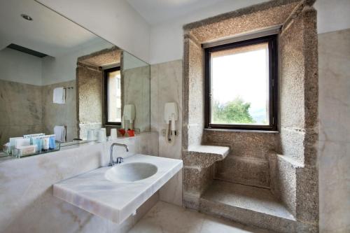 baño con lavabo y ventana en Pousada Mosteiro de Amares, en Bouro