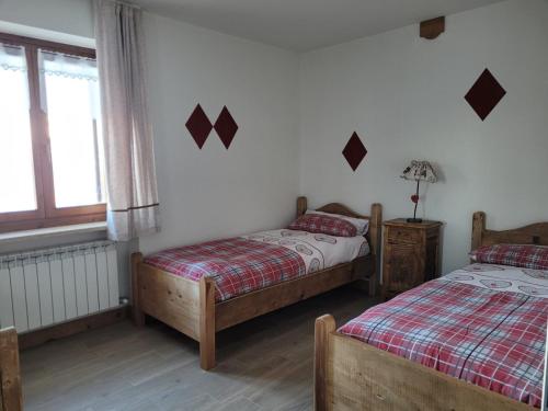 a bedroom with two beds and a window at Pila vacanze in Gressan