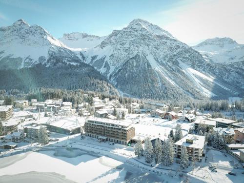 a resort in the snow with mountains in the background at Aves Arosa in Arosa
