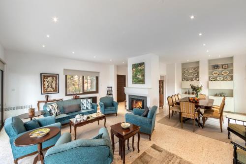 a living room with blue furniture and a fireplace at Platres Forty Pine Trees Cottage in Platres