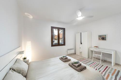 a white bedroom with a bed and a desk at Platres Forty Pine Trees Cottage in Platres