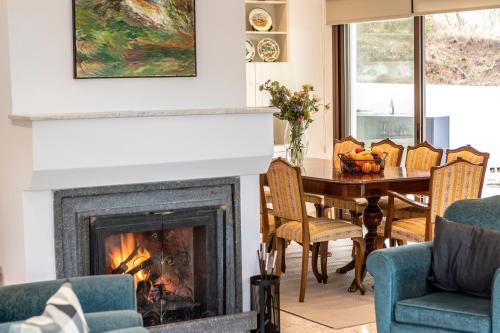a fireplace in a living room with a table and chairs at Platres Forty Pine Trees Cottage in Platres