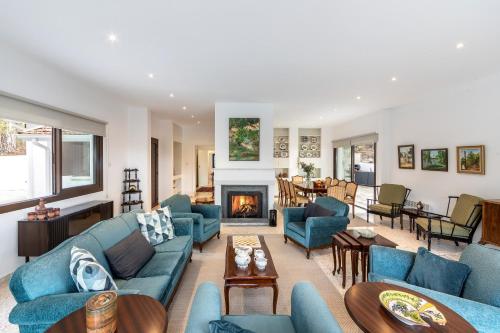 a living room with blue couches and a fireplace at Platres Forty Pine Trees Cottage in Platres