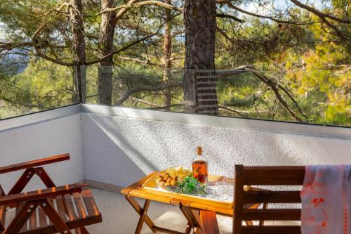 a table and chairs on a porch with a window at Platres Forty Pine Trees Cottage in Platres