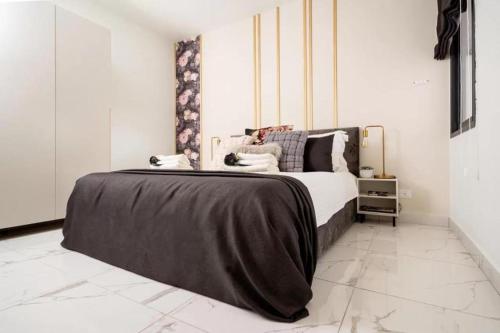 una camera da letto con un letto con una coperta nera sopra di HolySuite Even Israel a Gerusalemme