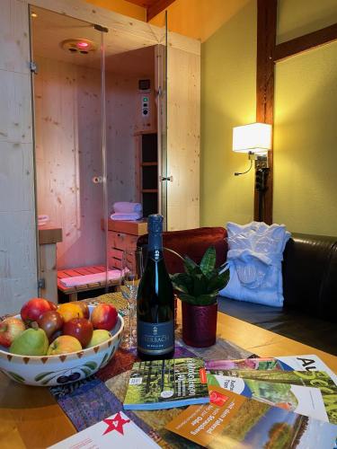 a bottle of wine and a bowl of apples on a table at Zur Goldenen Kartoffel in Prötzel