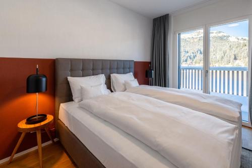 a bedroom with two beds and a large window at Aves Arosa in Arosa