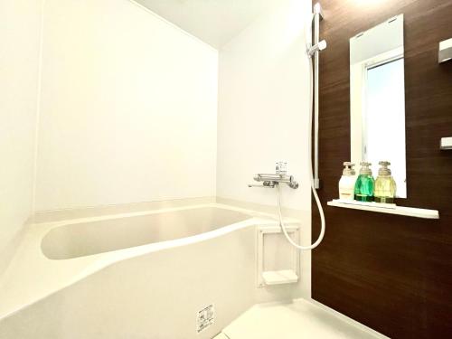 ein Badezimmer mit einer Badewanne und einem Waschbecken in der Unterkunft Luana Uakoko Resort 旧 EmiFull Resort in Chatan
