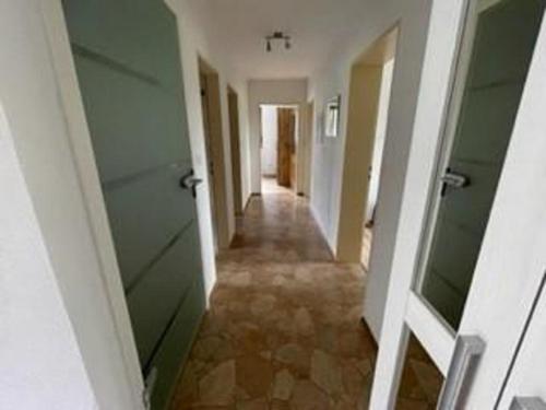 a hallway with green doors and a tile floor at Haus Gertraud Schreiner in Neuschönau