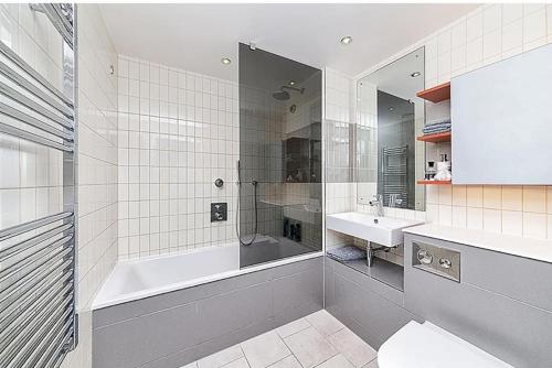 a bathroom with a shower and a tub and a sink at Off 12 in London