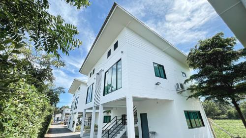 a white house with black windows at Z-Beach Resort in Ban Nong Ban Kao