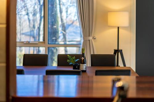 a conference room with a table and a bottle of wine at Suite Villa Nasukogen Terrace in Nasu