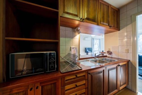 a kitchen with a microwave and a sink at Suite Villa Nasukogen Terrace in Nasu