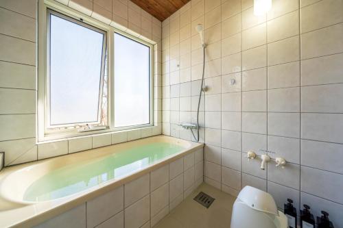 那須町にあるスイートヴィラ那須高原テラスのバスルーム(バスタブ付)、窓が備わります。