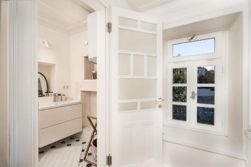 a bathroom with a white door and a sink at MINIQ HOMES 102 - Historical Stone House with Garden Cinema in Foça