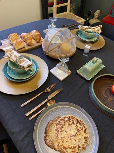 uma mesa azul coberta com pratos de comida e pão em Boutique B&B- The Riverside Retreat em Jarnac