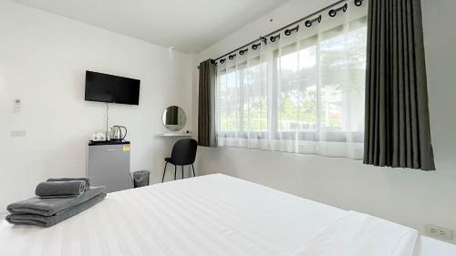 a white bedroom with a large bed and a window at Z-Beach Resort in Ban Nong Ban Kao