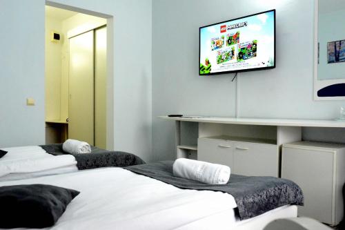 Cette chambre dispose de 2 lits et d'une télévision murale. dans l'établissement Hotel Soimul, à Poiana Brasov