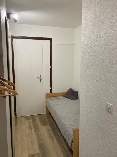 a small bedroom with a bed and a sliding door at studio Les Glieres in Bourg-Saint-Maurice