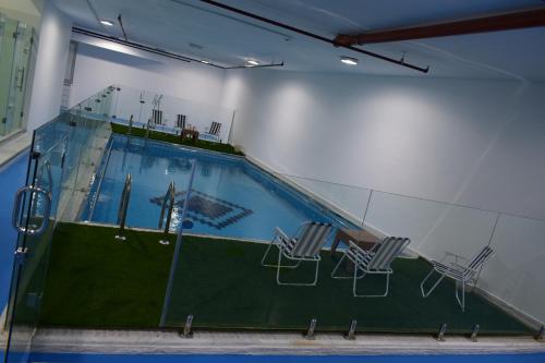 a swimming pool with two chairs and a table at Atlantis International Hotel Apartments in Kuwait