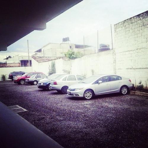 a row of parked cars in a parking lot at Hotel & Suites Mo Sak in Tapachula