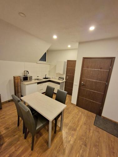 a kitchen with a table and chairs in a room at KALIDA Rooms for rent in Raseiniai