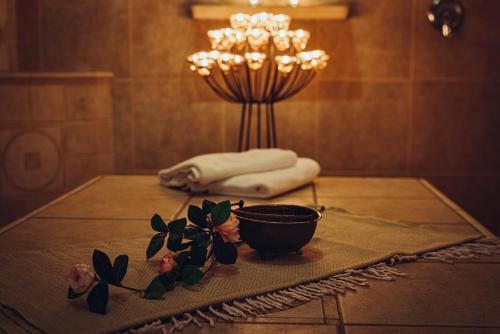 a table with a bowl and flowers on it at Pohorje Village Wellbeing Resort - Family Apartments Bolfenk in Pohorje