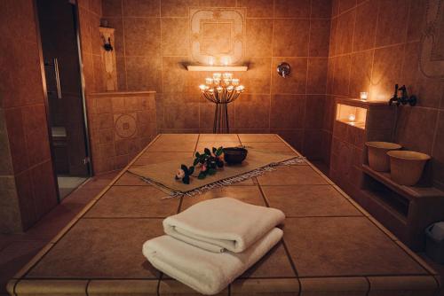 a bathroom with a table with towels on it at Pohorje Village Wellbeing Resort - Family Apartments Bolfenk in Pohorje
