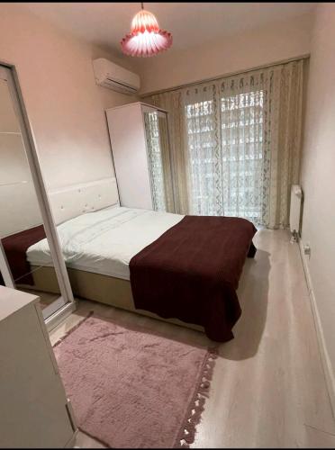 ein Schlafzimmer mit einem Bett und einem großen Fenster in der Unterkunft Batışehir Bağcılar in Bağcılar