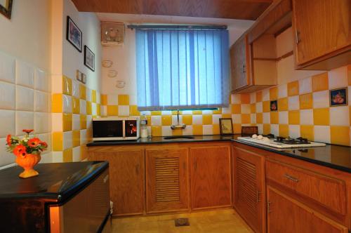 a kitchen with yellow and white tiled walls at European Complex in Bhurban