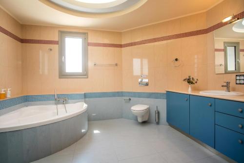 KoskinouにあるAegean Blue Villaのバスルーム(バスタブ、トイレ、シンク付)