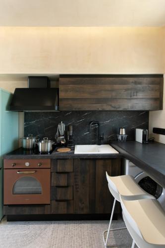 a kitchen with a sink and a stove at Eden Beachfront Residences & Suites in Kastraki Naxou