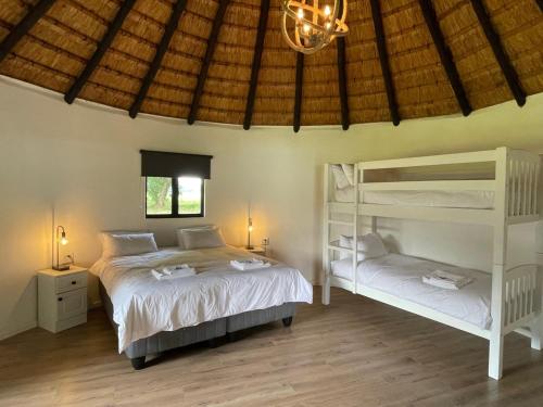 a bedroom with two beds and a bunk bed at Dieu Donne Cottage in Underberg