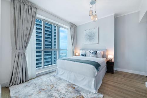 - une chambre avec un grand lit et une grande fenêtre dans l'établissement Maison Privee - High-Floor Trendy Apt with Marina, Palm & Ocean Vws, à Dubaï