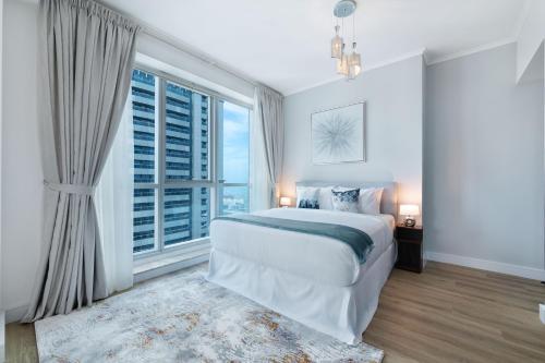 a bedroom with a large bed and a large window at Maison Privee - High-Floor Trendy Apt with Marina, Palm & Ocean Vws in Dubai