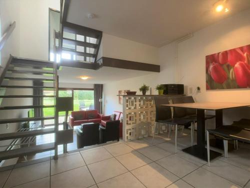 een woonkamer met een trap en een tafel en stoelen bij Wijk de Brabander 58 in Cadzand