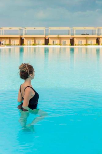 a woman sitting in the water in a swimming pool at Marom Port Said Resort & Beach in Port Said