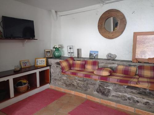 ein Wohnzimmer mit einem Sofa und einem TV in der Unterkunft Ca de Blasi in Taull