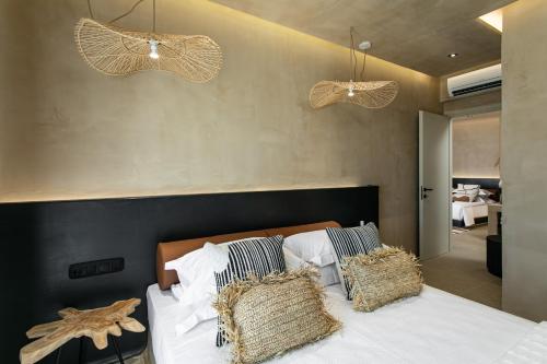 a bedroom with a bed with white sheets and pillows at Eden Beachfront Residences & Suites in Kastraki Naxou