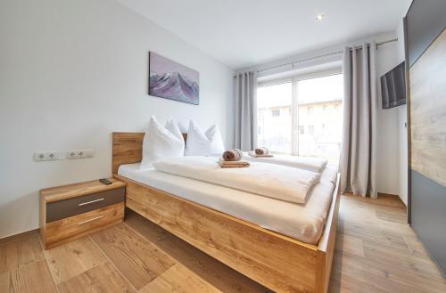 een slaapkamer met een groot bed en een raam bij Appartement Atzingerberg in Maishofen