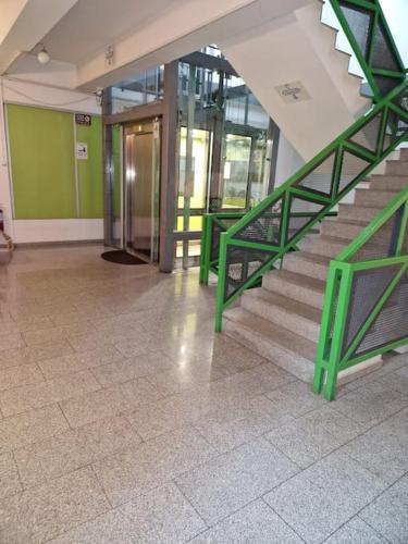 Una escalera en un edificio con barandilla verde. en Studio modern., en Bucarest