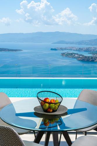 a glass table with a bowl of fruit on it at Majestic View Villas in Agios Nikolaos