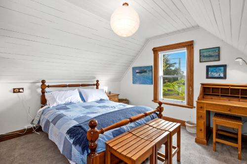 a bedroom with a bed and a piano at The Professor's Beach House - Brighton Home in Mosgiel