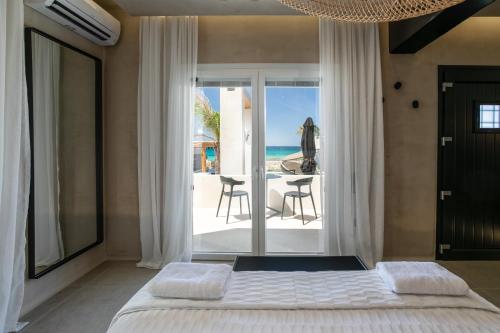 a bedroom with a bed and a view of the ocean at Eden Beachfront Residences & Suites in Kastraki Naxou